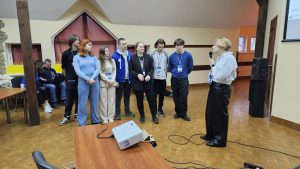 Захист командного проєкту в рамках ML WEEK 2025, група учасників і викладачка з мікрофоном